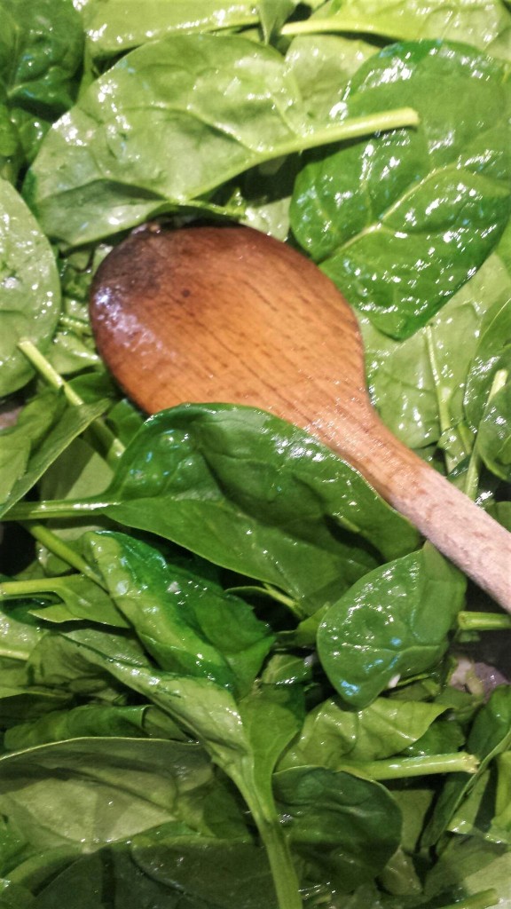 Add fresh spinach and water to garlic